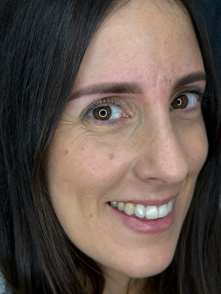 Mujer sonriendo con las cejas perfiladas