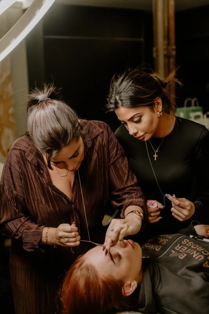 Alumnas practicando la depilación de cejas con hilo